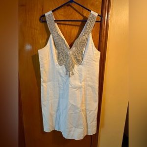 White lily dress with gold embroidery on top.